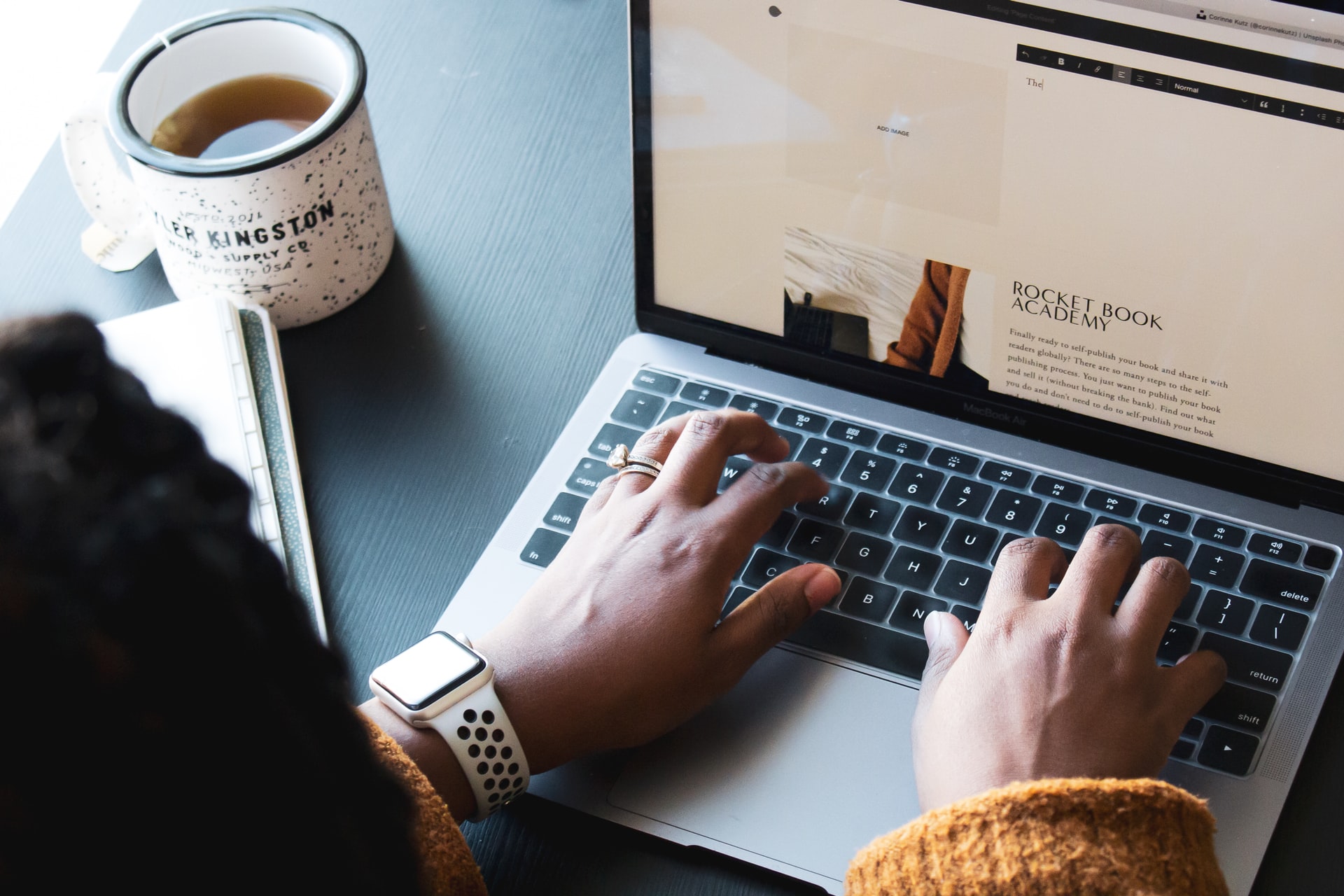 A picture of a woman typing, taking advice from Elijah Norton on business success.